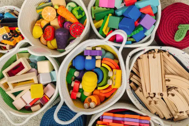 Spielsachen in unterschiedlichen Behältern zum Thema Ordnung im Kinderzimmer