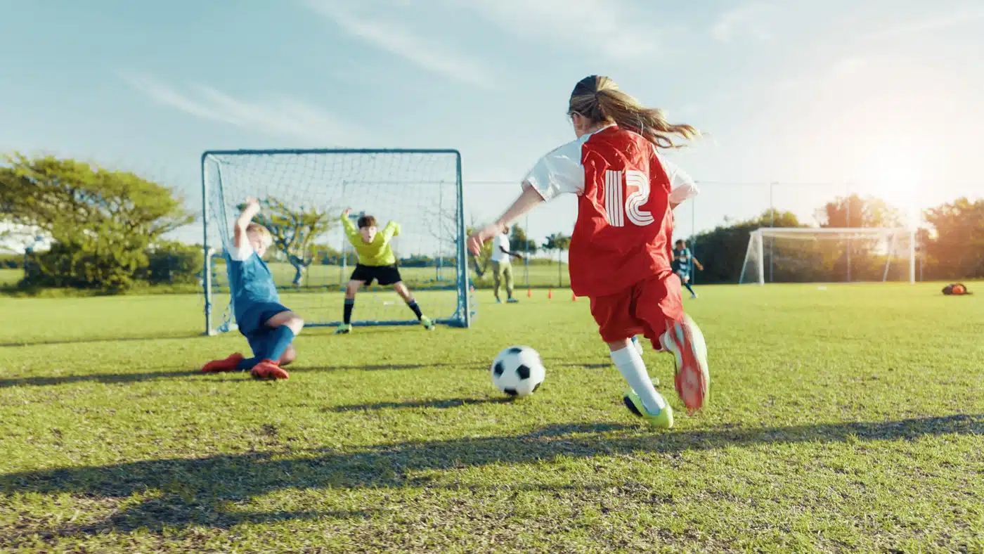 Mädchenfußball im Jugendtraining – sportliche Aktion beim Torschuss auf dem Bolzplatz