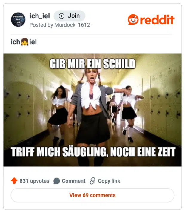 Ein Meme basierend auf dem Musikvideo von Britney Spears’ „...Baby One More Time“, in dem sie mit Tänzerinnen durch einen Schulflur läuft. Oben steht der Text: „GIB MIR EIN SCHILD“, unten: „TRIFF MICH SÄUGLING, NOCH EINE ZEIT“ – eine absurde, wortwörtliche Übersetzung des englischen Songtextes „Hit me baby one more time“.