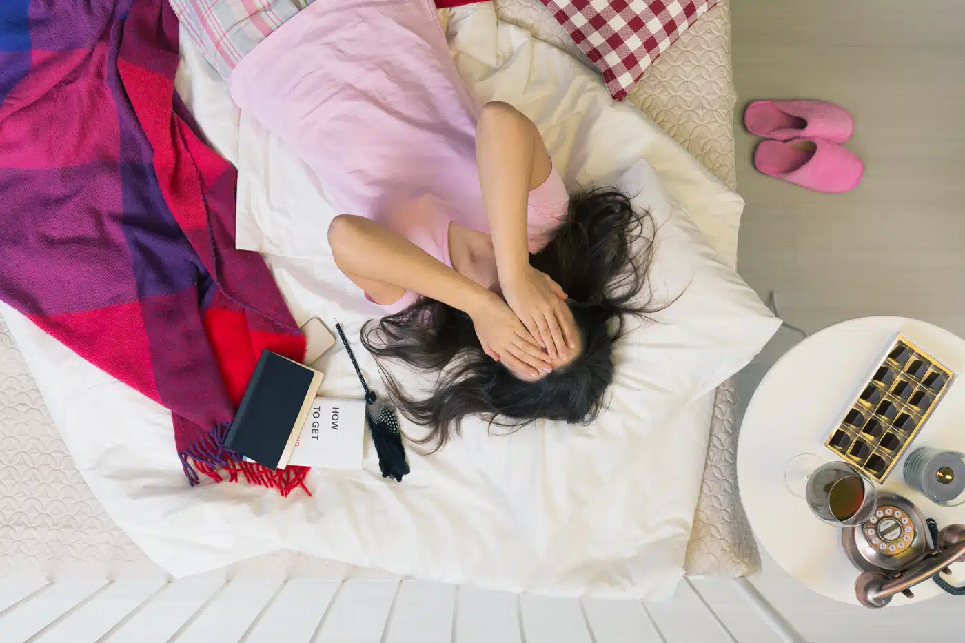 Junge Frau im Pyjama leidet unter Stress oder Liebeskummer – Alltag zwischen Selbsthilfe, Schokolade und Erschöpfung