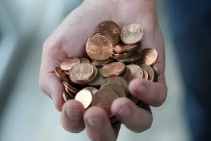 Hand hält viele 1- und 2-Cent-Münzen – Kleingeld in Euro-Währung