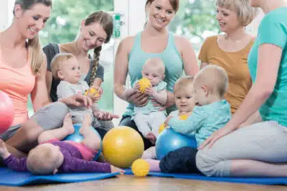 Mütter mit Babys beim Eltern-Kind-Kurs oder der Krabbelgruppe in heller Umgebung – Symbolbild für Frühförderung, Gemeinschaft und Elternzeit