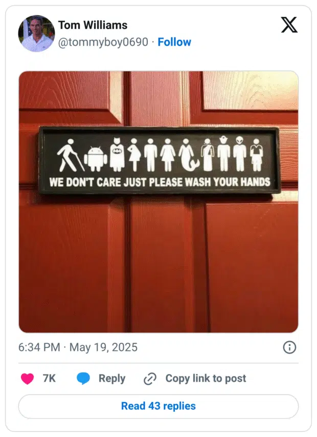 Ein humorvolles Schild an einer roten Tür zeigt stilisierte Figuren verschiedenster Art – darunter Menschen unterschiedlicher Geschlechter, ein Android, Batman, eine Meerjungfrau, ein Alien und weitere – mit der Aufschrift: „WE DON'T CARE JUST PLEASE WASH YOUR HANDS“. Die Botschaft lautet: Egal, wer du bist – Hauptsache, du wäschst dir die Hände.