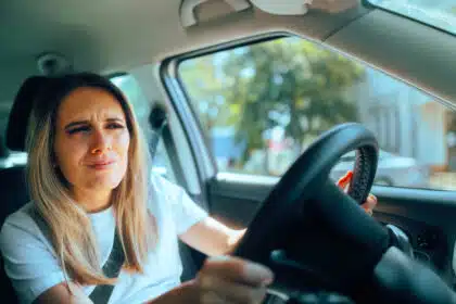 Autofahrerin sitzt in einem PKW und ärgert sich