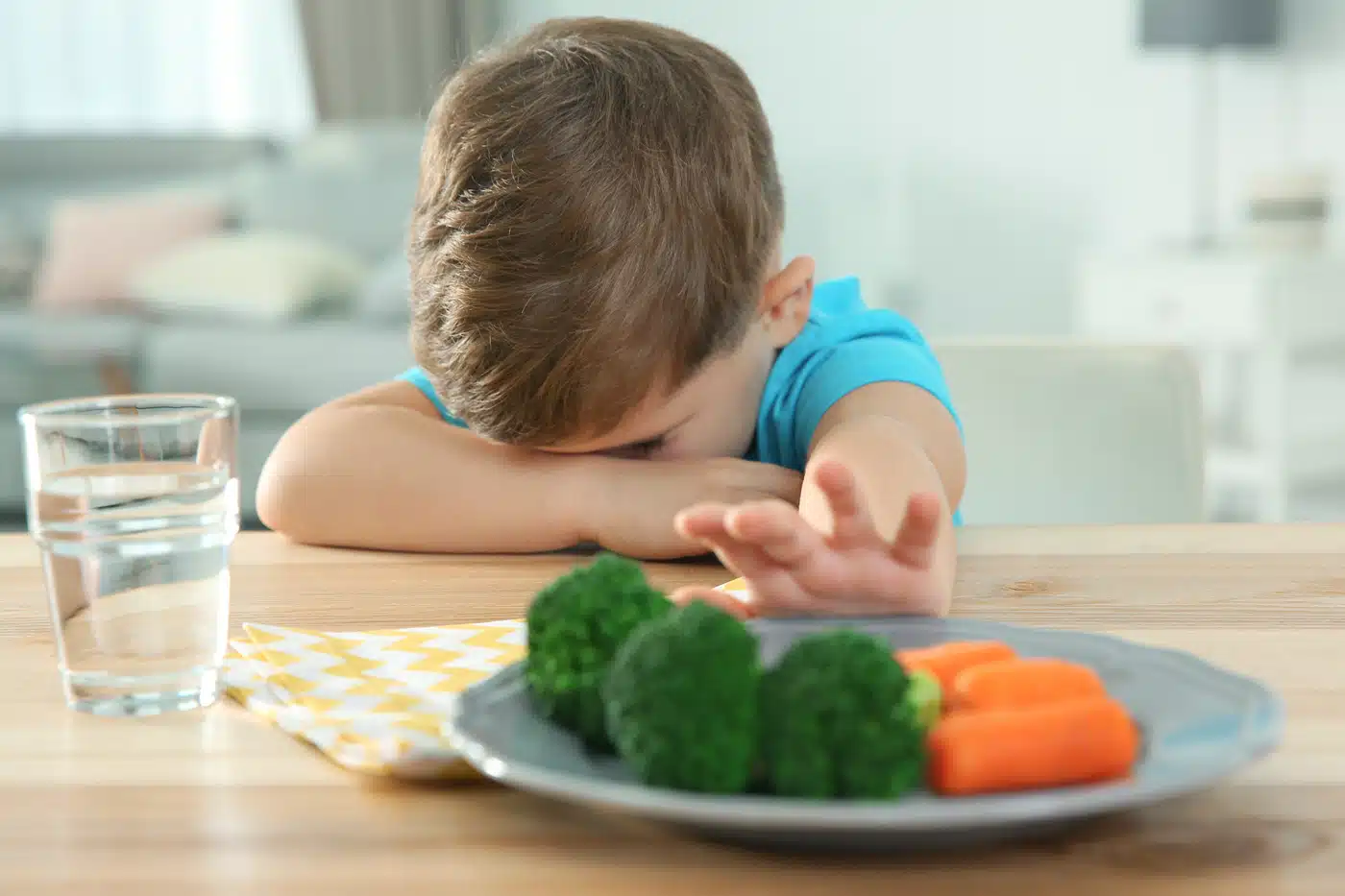 Essen mit Kindern ist nicht immer leicht. Ein Kind weigert sich, Gemüse zu essen.