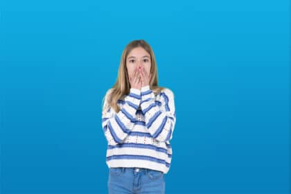 Junges Mädchen schaut schockiert und hält die Hände vor den Mund.