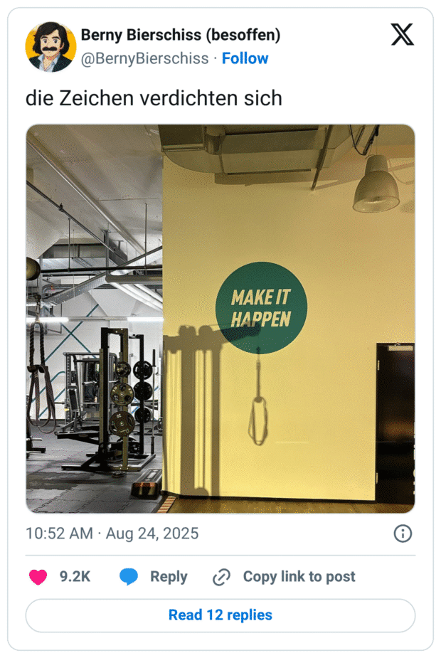 Fitnessstudio mit Gerätestationen. An einer gelben Wand steht groß „MAKE IT HAPPEN“. Durch das Licht wirft ein Trainingsgriff daneben einen langen Schatten, der wie eine Schlaufe wirkt – unglückliche Bildkombination mit dem Motivationsspruch.