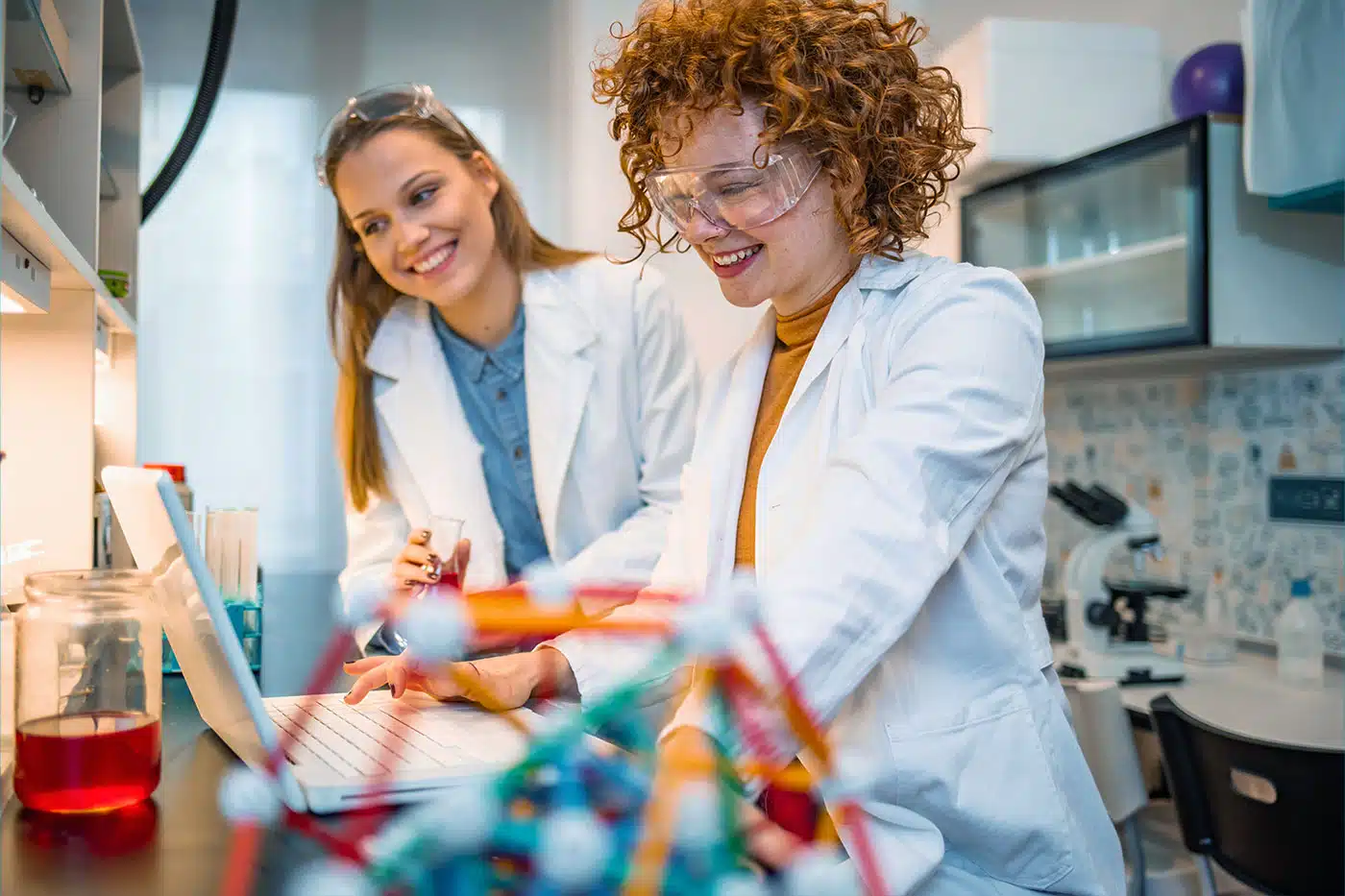 Zwei junge Frauen arbeiten im Physikunterricht im Labor an einer Studie.