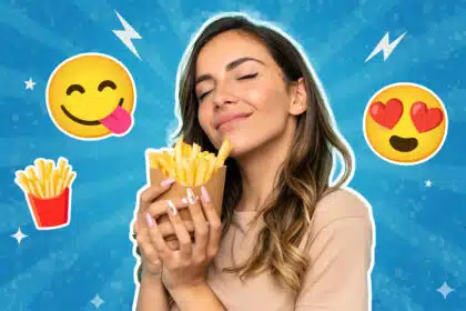 Eine junge Frau hält glücklich eine Portion Pommes in den Händen und schließt genüsslich die Augen; im Hintergrund sind Emojis mit Herzaugen, heraushängender Zunge und Pommes-Symbol auf blauem, grafischem Hintergrund zu sehen.