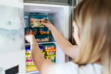 Eine Frau stapelt penibel bunte Dosen im Gefrierschrank – und weiß: Das ist jetzt entweder Ordnung oder schon eine leichte Obsession.