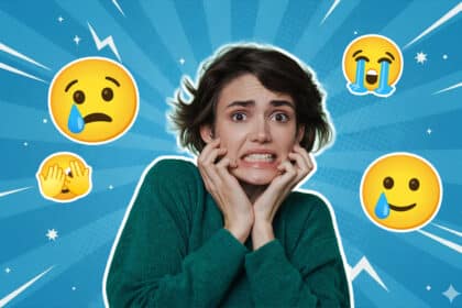 Eine Frau mit kurzem dunklem Haar trägt einen grünen Pullover und wirkt angespannt oder gestresst, mit verkrampften Händen im Gesicht. Um sie herum sind weinende, besorgte und peinlich berührte Emojis vor einem blauen Strahlenhintergrund – Symbol für Überforderung oder emotionale Anspannung.