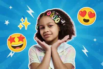 Ein Mädchen mit vielen bunten Haarklammern im Haar posiert lächelnd mit den Händen unter dem Kinn vor einem blauen Hintergrund. Um sie herum sind Emojis mit Herz- und Sternaugen sowie funkelnde Sterne zu sehen.