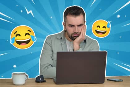 Ein Mann sitzt nachdenklich vor einem Laptop, stützt den Kopf in die Hand und schaut auf den Bildschirm; um ihn herum sind lachende Emojis auf blauem, grafischem Hintergrund zu sehen.