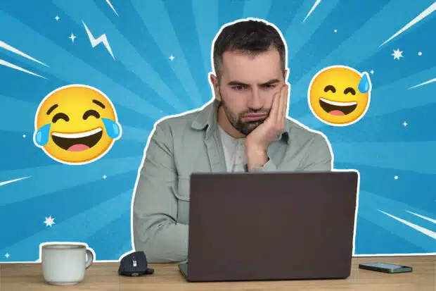 Ein Mann sitzt nachdenklich vor einem Laptop, stützt den Kopf in die Hand und schaut auf den Bildschirm; um ihn herum sind lachende Emojis auf blauem, grafischem Hintergrund zu sehen.