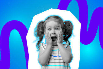 Ein kleines Mädchen mit zwei Zöpfen hält sich überrascht die Hände an die Wangen und schaut mit weit geöffnetem Mund nach vorn, vor einem farbenfrohen, blau-lila Hintergrund.