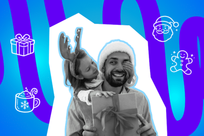 Ein Mann mit Weihnachtsmütze hält ein Geschenk, während ein Kind mit Rentier-Haarreif ihm lachend die Augen zuhält.