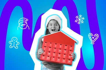 Ein Kind hält begeistert einen roten Adventskalender mit nummerierten Türchen in den Händen. Es trägt eine Wintermütze und schaut mit offenem Mund freudig überrascht.