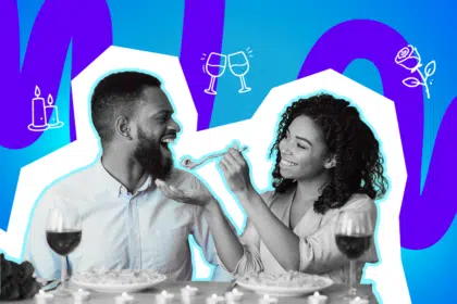 Lächelndes Paar sitzt bei einem romantischen Dinner, während die Frau dem Mann liebevoll Essen reicht, vor einem bunten, grafischen Hintergrund mit Kerzen-, Herz- und Weinsymbolen.