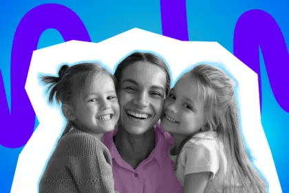 ine Mutter lächelt glücklich zwischen zwei Kindern, die sie umarmen.