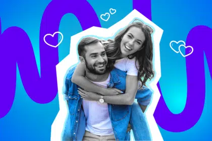 Ein junges Paar lacht fröhlich, während die Frau dem Mann von hinten um den Hals fällt, vor einem farbigen Hintergrund mit Herzsymbolen.