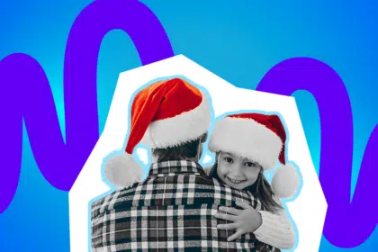 Ein Elternteil und ein Kind umarmen sich mit Weihnachtsmützen. Das Bild strahlt Nähe, Wärme und festliche Geborgenheit aus.