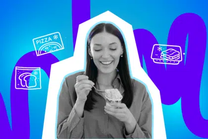 Lächelnde Frau hält Eis in der Hand und nimmt glücklich einen Löffel davon.