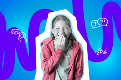 Mädchen hält sich kichernd die Hand vor den Muns.