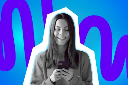 Frau schaut glücklich und gespannt in ihr Handy und liest.