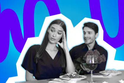 Eine Frau wirkt genervt, während ihr Gegenüber mit Blumen gut gelaunt am Tisch sitzt. Das Bild steht für schräge oder unpassende Eigenschaften in Beziehungen.