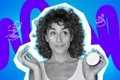 Zufrieden lächelnde Frau mit Locken, die sich Creme ins Gesicht getupft hat und einen Tiegel in der Hand hält. Die Pop-Art-Illustration fängt den Moment der täglichen Hautpflege-Routine humorvoll ein.